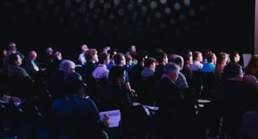 crowd of people sitting on chairs inside room