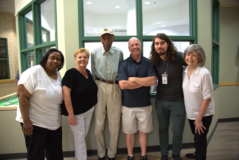 Group of people standing together and smiling for the camera.