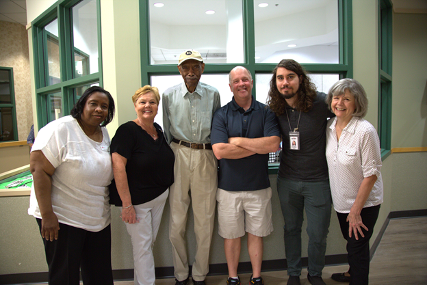 Group of people standing together and smiling for the camera.