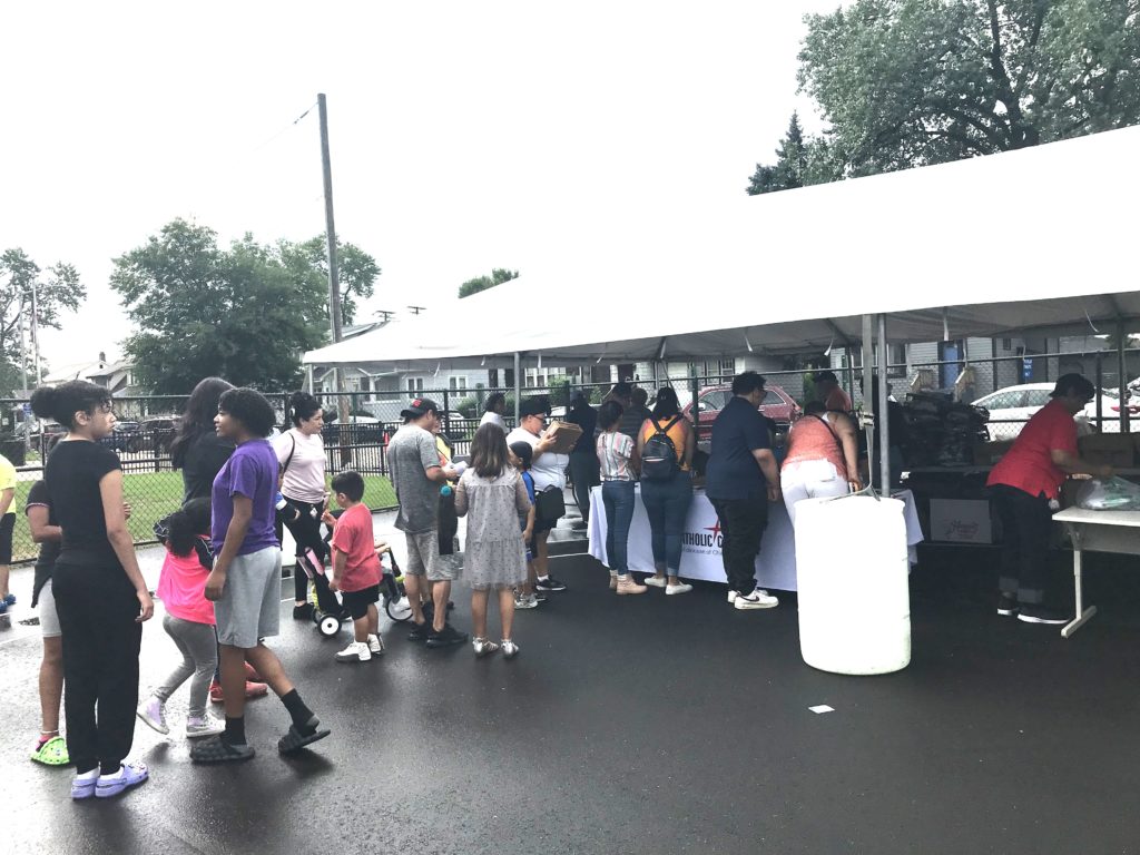 People outside in line for backpacks.