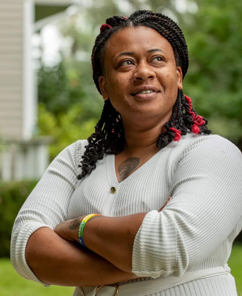 Woman with arms crossed looking off into the distance